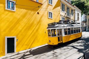 Fotografi Yellow tram moving past yellow building, Alexander Spatari