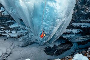 Konstfotografering A woman ice climbs up a, Alex Ratson, (40 x 26.7 cm)