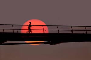 Fotografi Man out for morning run over bridge., Grant Faint, (40 x 26.7 cm)