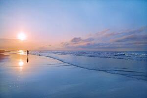 Konstfotografering Person walking on beach at sunrise, Shannon Fagan, (40 x 26.7 cm)
