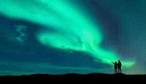 Fotografi Aurora borealis and silhouette of man and woman, den-belitsky