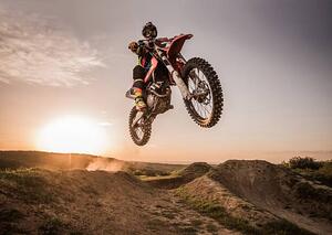 Fotografi Motocross rider performing high jump at sunset., skynesher