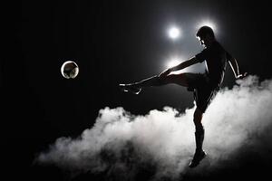 Fotografi Soccer player kicking the ball at night on stadium, Stanislaw Pytel