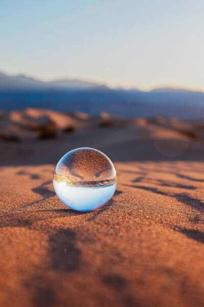 Konstfotografering Glass Sphere on Desert Sand, Lena Wagner, (26.7 x 40 cm)